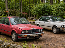 Red and white BMW E30s illustrating different body conditions