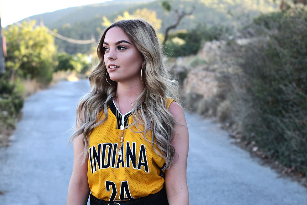 blonde model in at sunset on road in ibiza yellow basketball top