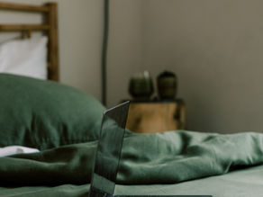 Laptop open on a bed, working on yourself.