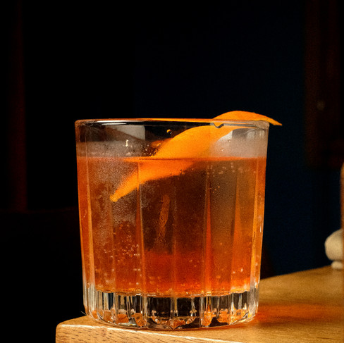 cocktail in rock glass with an organe peel