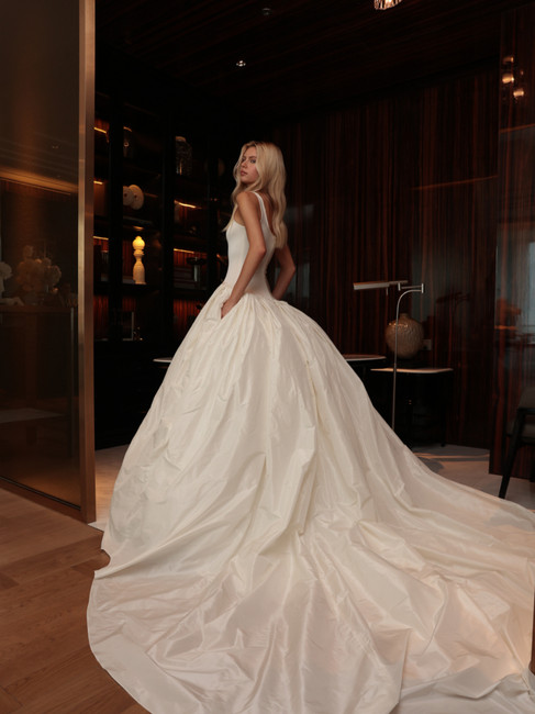 models showing white, floor-length wedding dresses by ASAVA in luxury hotel setting and romantic ambient lights
