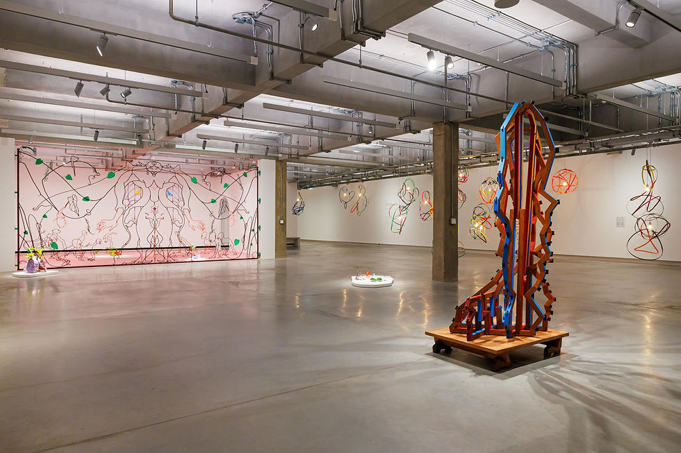 Abstract sculptures and wire installations in a spacious modern gallery with polished concrete floors and industrial ceiling beams.
