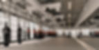 Empty boxing gym with hanging heavy bags, mirrored wall, and EVOLVE ring branding in a bright modern studio.