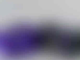 two laundry bags, deep purple and black, laid side by side on the floor