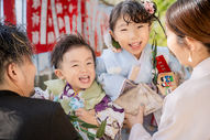 家族に囲まれて笑う3歳男の子とお姉ちゃんの七五三