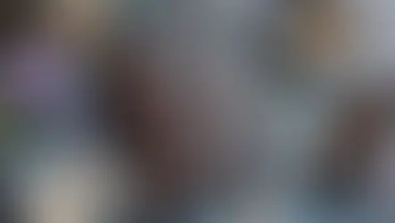 Caderno místico de capa marrom cercado por cristais, incensos e pedras naturais sobre superfície azul, simbolizando espiritualidade e rituais energéticos.