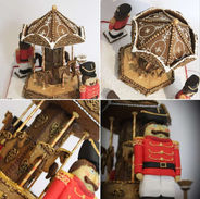 Edible gingerbread carousel decorated with royal icing, candy cane poles, and miniature horses, surrounded by nutcracker cookie figures and a snow-like icing base.
