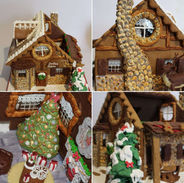 Edible gingerbread Santa’s cabin with round window, stone chimney, chocolate reindeer, and open roof showing a tree, fireplace, and armchair inside.