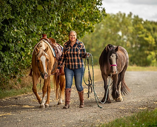 Jennifer Sheerin professional western saddle fitter in the UK with two horses walking on a dirt road