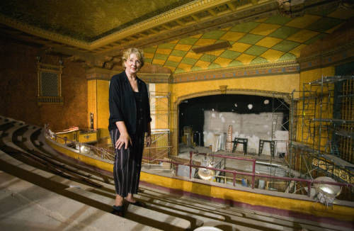 A woman stands at the edge of the balcony in the unfinished Gillioz. Behind and beneath her, scaffolding and repairs are scattered throughout the auditorium.