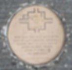 A shiny brass round medallion embedded in asphalt with a map of the Springfield square etched in it. The map shows the locations of Tutt and Hickok along with an inscription about Tutt's death.