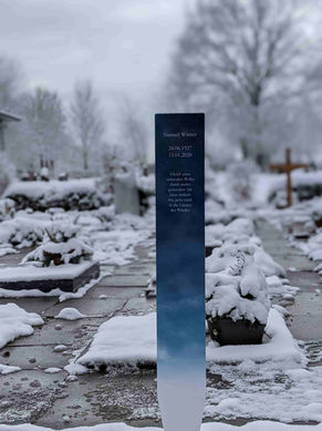 Grabstele auf einem Friedhof mit aufgedruckten Wolken zur Symbolisierung des Himmels.