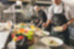 Chefs cooking various dish in kitchen. Focused and professional atmosphere.