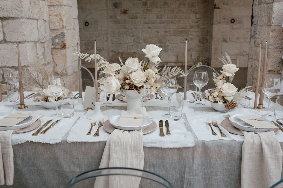 stillvolle-tischdekoration-mit-weißen-blumen-und-spitzen-kerzen