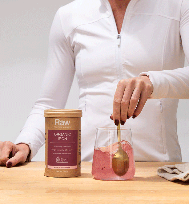 Raw by Amazonia Organic Iron product shown with a person stirring a drink in a glass.