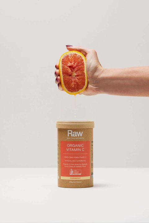 Raw by Amazonia Organic Vitamin C product styled with fresh orange and minimalist campaign photography.