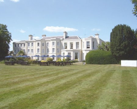 Wide-angle view of a Georgian manor house surrounded by wedding gardens.