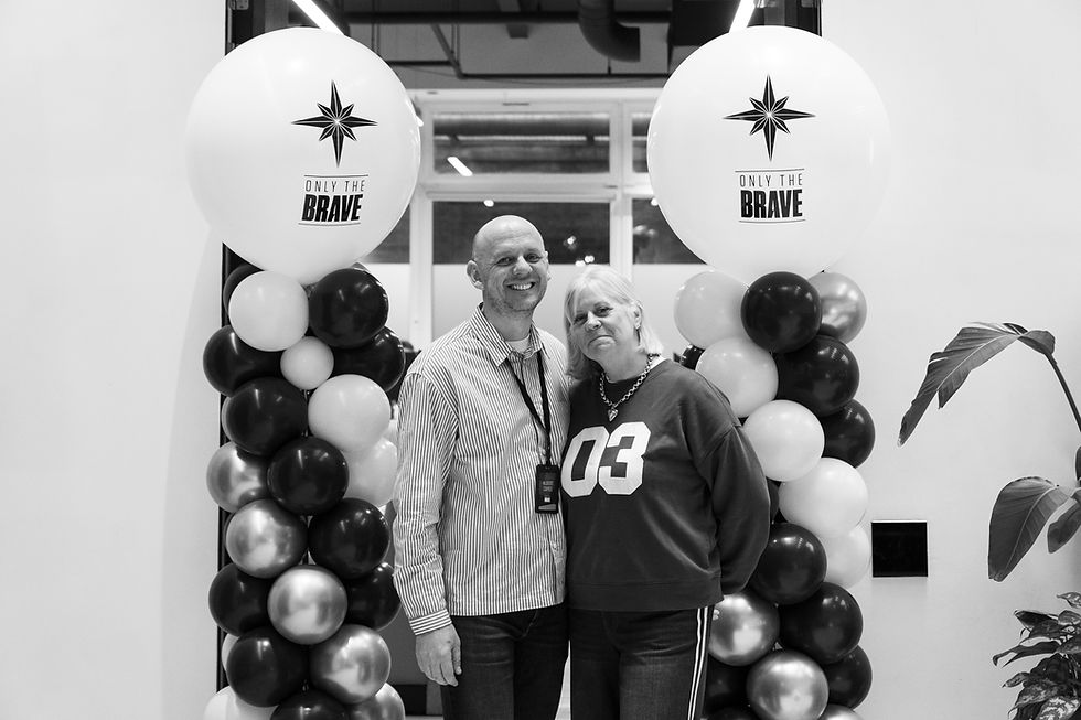 Team members standing and smiling in front of balloons