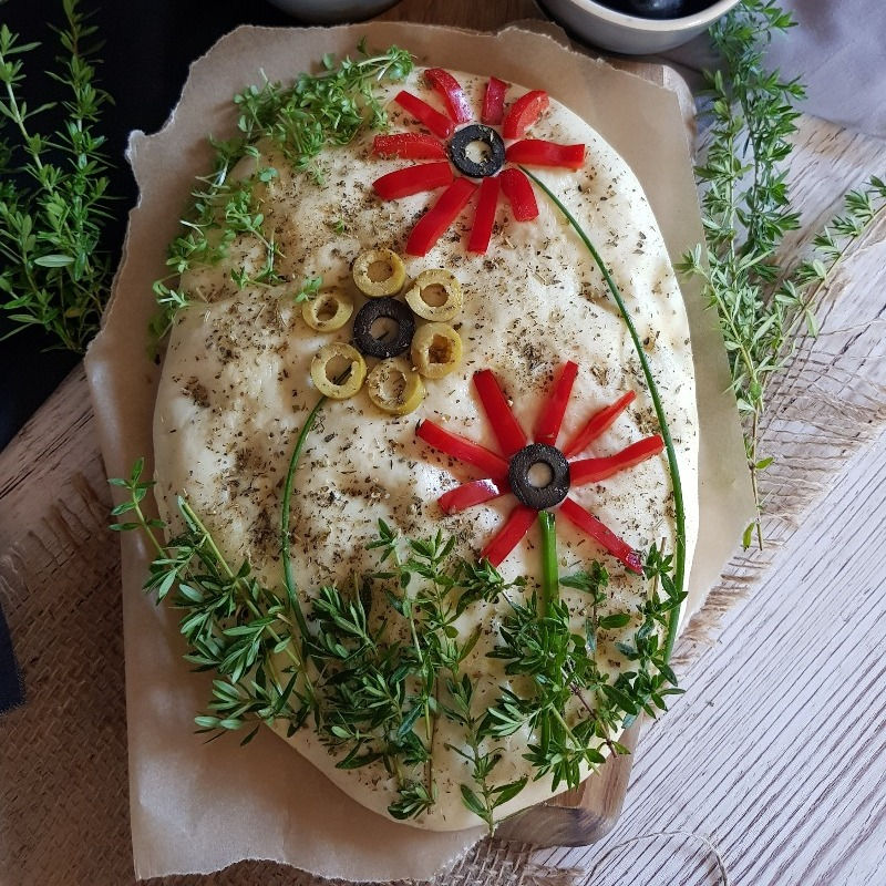 Focaccia ist ein Fladenbrot mit Kräutern verzehrt nach einem Garten Muster
