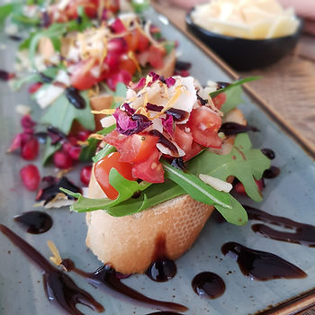 Bruschetta, kleine Baguette belegt mit Rucola, klein geschnittene Tomaten, ein perfekter Begleiter zum Grillen, ein gesunder Snack für Abend, eine Inspiration für die Gäste