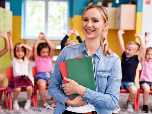 Smiling early years teacher with young children in a nursery classroom
