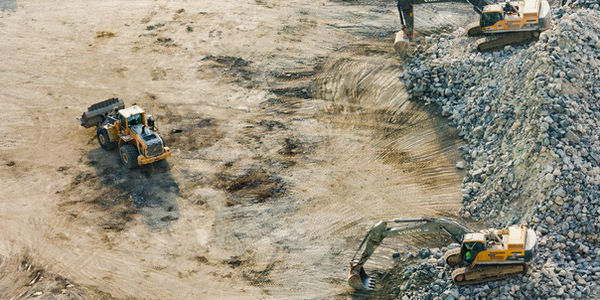 Two construction workers reviewing plans on a work site.