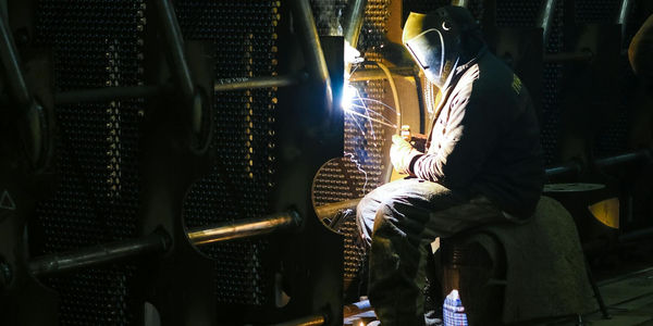 A group of people collaborating around a table with blueprints, representing hands on learning in trade school.