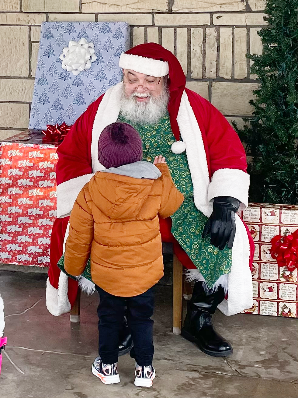 Santa at the Bachman Lake Pavilion greets small child.
