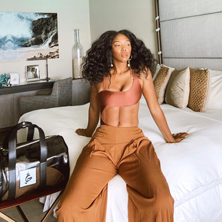 Model on a bed with brown clothes 