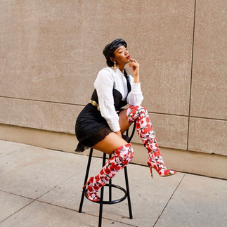 Model sitting on chair with a black hat