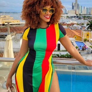 Model with multi-colored dress standing in front of city