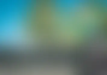 Worker cleaning house gutters with a pressure washer.