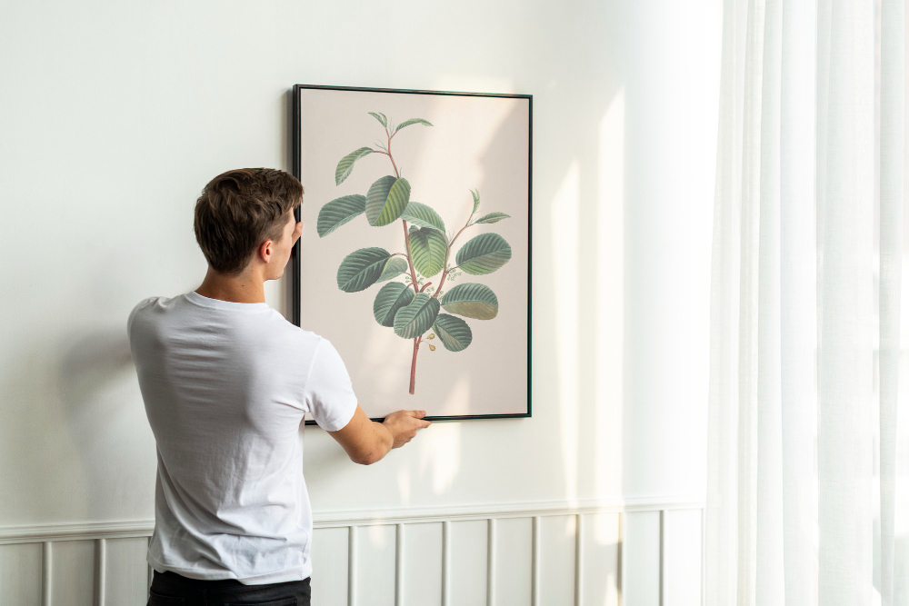 Person adjusting framed chart with circular nodes and connecting lines, presenting data visually.