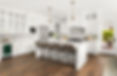 Modern kitchen with white cabinets, wood floors, kitchen island with seating, and stainless steel appliances