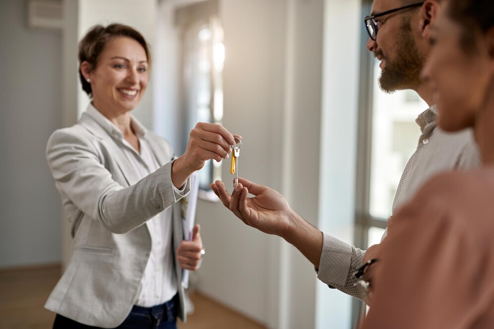 happy-real-estate-agent-giving-couple-keys-their-new-home_637285-6089.jpg