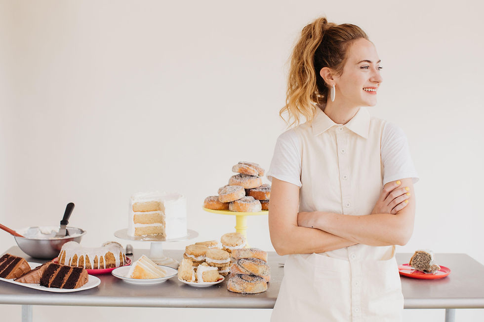 woman pastry chef smiling with baked goods