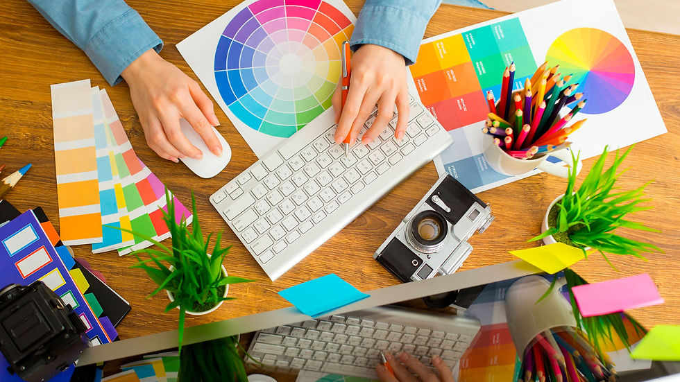 Design Desk with paper and colors and cameras and graphics and more.