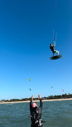 Kitesurfer der über den Kitesurf Lehrer springt
