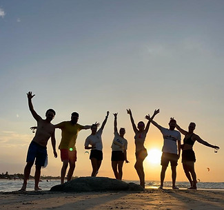 Gruppe Freunden im Sonnenuntergnag am Strand