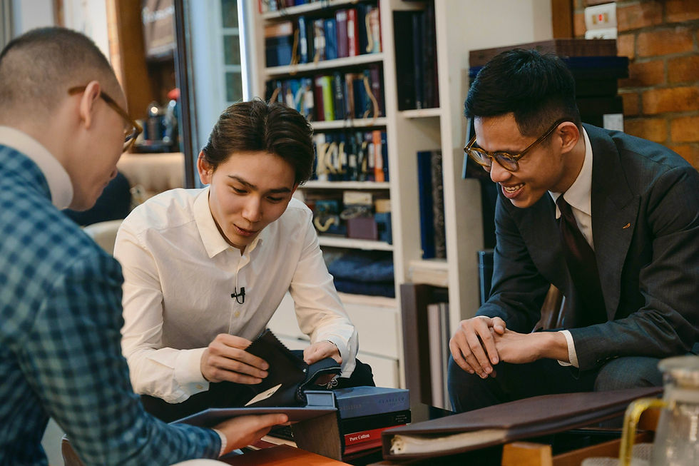 Carlo Pham's staff is consulting suit models for customers to refer to