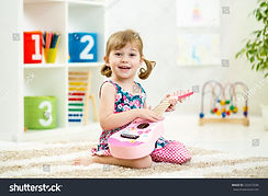 stock-photo-kid-girl-playing-guitar-toy-at-home-232472596.jpeg