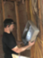 man hanging electrical panel on wall