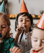 Kids at a birthday party playing with colorful pin noise makers