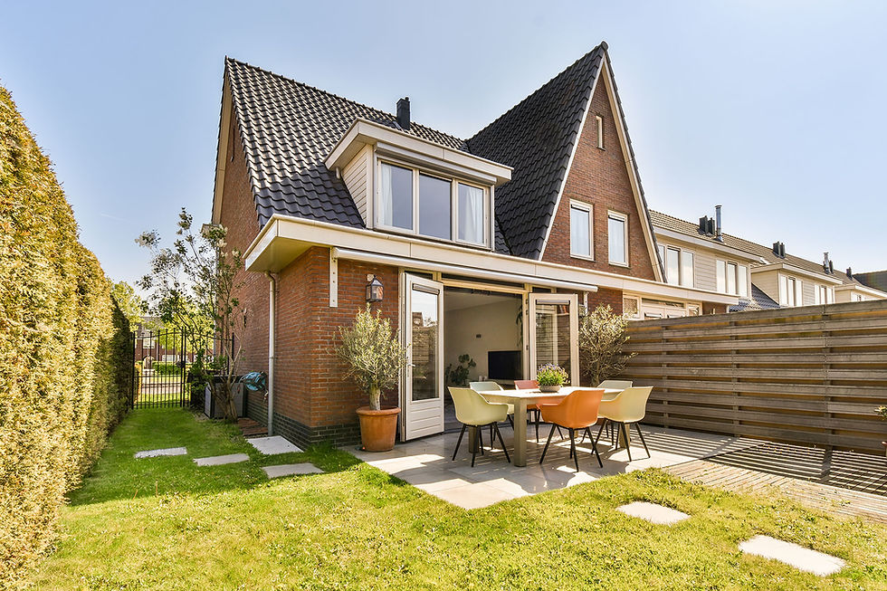 Moderne Nederlandse woning met zonnepanelen, donkere gevelbekleding en rode bakstenen, omgeven door groen.