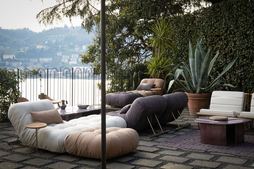 Minimalist outdoor furniture without metal hardware on a luxury terrace overlooking a seascape.