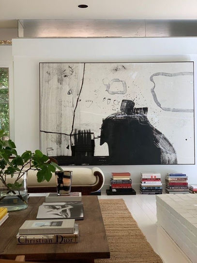 Large-scale abstract painting on an accent wall in a modern estate with low-profile furniture.