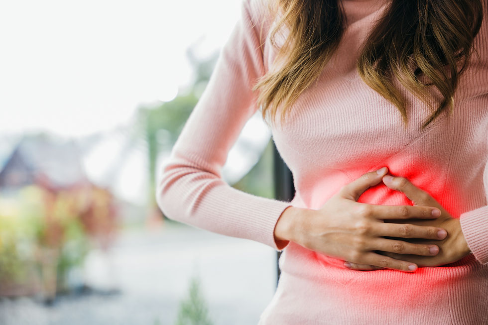 Woman in a pink sweater clutching her stomach, highlighting pain with a red glow, in a blurred outdoor setting.