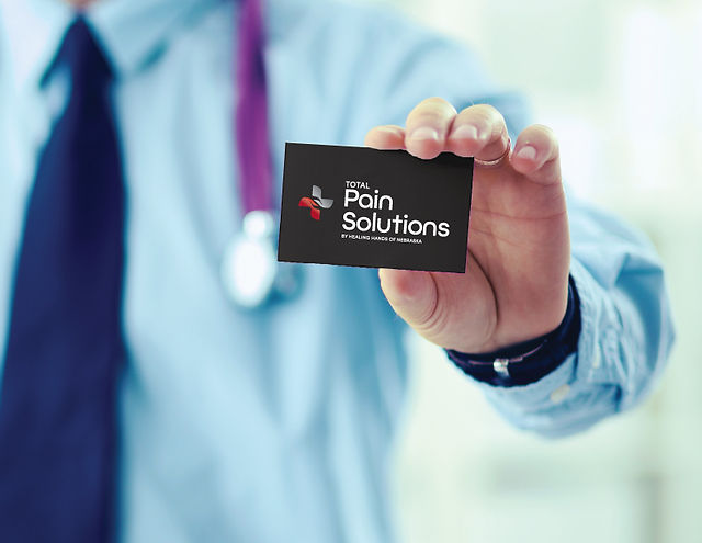 man holding business card for Total Pain Solutions