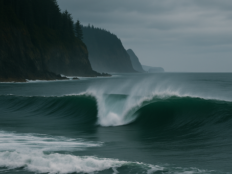 Rugged Oregon North Coast waves rolling into a misty cove beneath cliffs and sea stacks, showing the dramatic cold-water surf conditions of the Pacific Northwest.