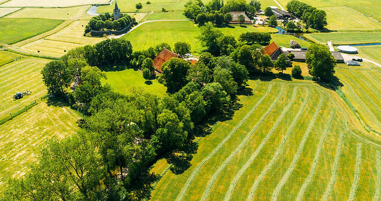 aerial-view-of-farmland-with-farmer-houses-and-a-church-in-friesland-the-netherlands-AAEF0